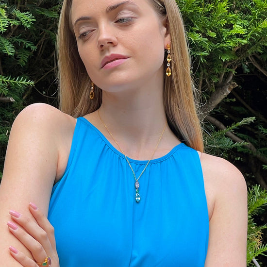 Model wearing purple amethyst and blue topaz and agate drop necklace 