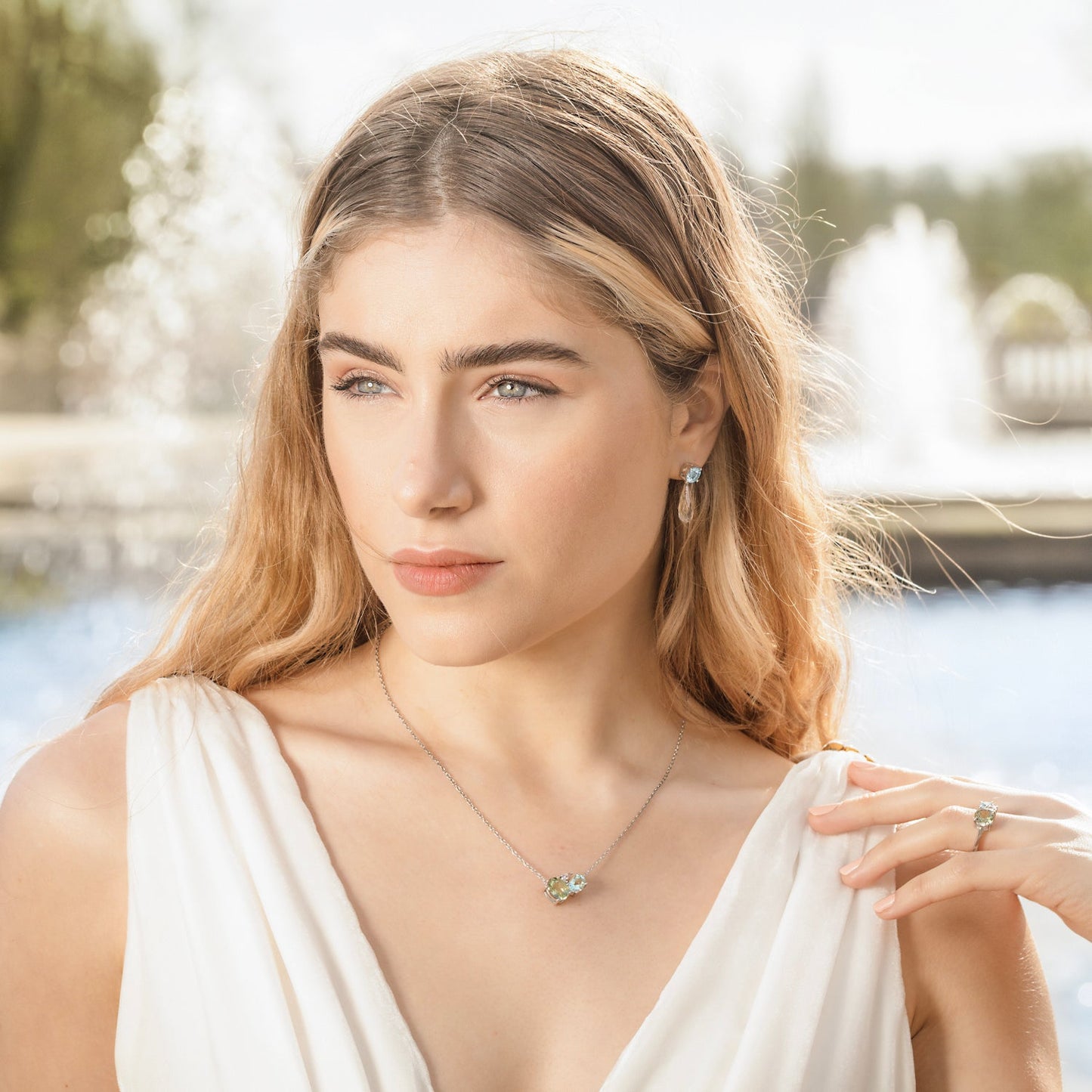 British Jewellers designed London-made custom gold jewellery – Model demonstrating the wear of the Green Amethyst and Aquamarine Drop Earrings and the Green Amethyst Silver Cluster Necklace – Como Collection, Augustine Jewellery, British Jewellers, Gemstone Jewellery, Luxury Jewellery London.